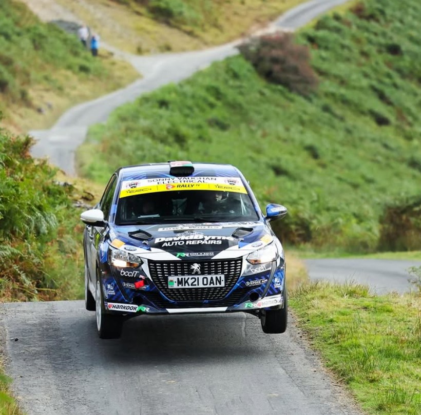 Rali Ceredion Peugeot 208 bouncing on winding country road in Wales