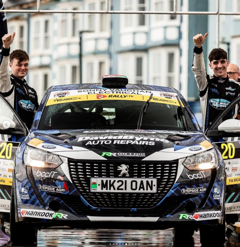 IOan Lloyd and Sion Williams standing beside their Peugeot 208 Rally4 from Tagai Racing Technology at Rali Ceredigion.