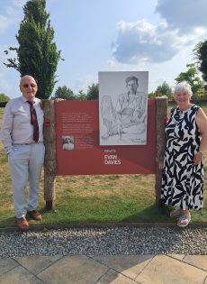 Angela Williams standing beside her father Evan Tyssul Davies' portrait at the VJ80 exhibition, National Memorial Exhibition portrait at the VJ80 exhibition - a story digitising memory to safeguard the future